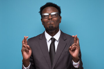 African young businessman making a wish crossing fingers