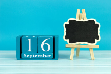 wooden calendar with the date of August 16 and an easel on a blue background, place for text, European Mobility Week,  International Day for the Preservation of the Ozone Layer