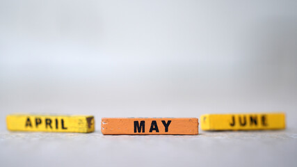 Wooden block calendar with focus on MAY, April June blur. silver background