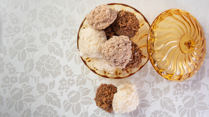 Brazilian cocada (coconut candy) placed in a glass jar on a table with white towel, selective focus.