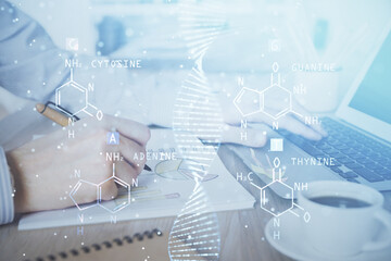DNA hologram with businessman working on computer on background. Concept of bioengineering. Double exposure.