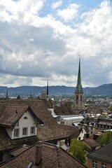 House roofs of Zurich with Predigerkirche and Grossmünster on a summer day with white clouds