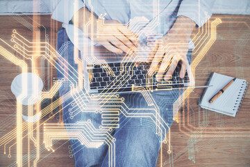 Technology theme hologram with man working on computer on background. High tech concept. Multi...