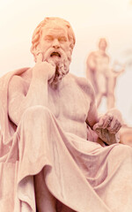 Socrates in front and Apollo blurred marble statues in the background, Athens Greece
