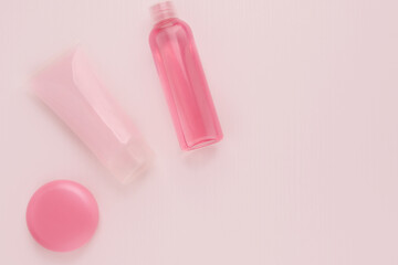 Cosmetics for beauty and skin care, makeup. Cleansing tonic, moisturizing and nourishing cream with collagen and lifting effect, lip balm on a pink background