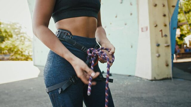 Close up of professional woman alpinist tying knot out of climbing rope
