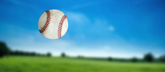 Baseball ball in the air, close up, sport games. Blurred natural landscape