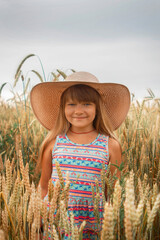 Girl in a hat in a whead field