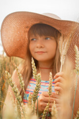 Girl in a hat in a whead field