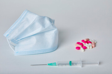 Seringue, masque et pillule sur fond Blanc