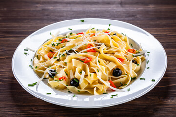 Pasta with parmesan and vegetables on wooden table
