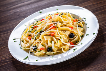 Pasta with parmesan and vegetables on wooden table
