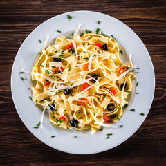 Pasta with parmesan and vegetables on wooden table
