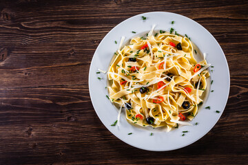 Pasta with parmesan and vegetables on wooden table
