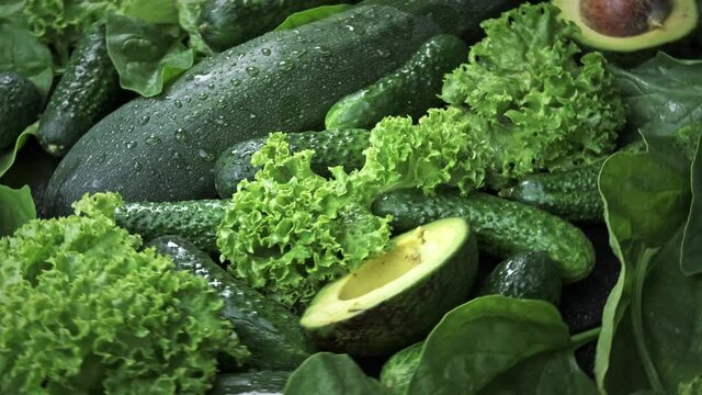 Green background of fresh lettuce leaves avocado cucumber zucchini