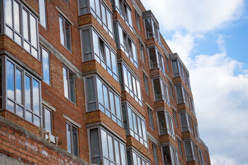 Fototapeta premium Sky above building crane at front of a multi-storey uilding under construction, new house for many families, babies and new life, building multi-storey building as symbol of hope to better life