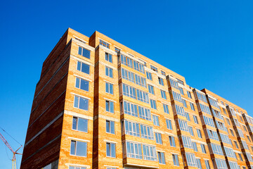 Sky above building crane at front of a multi-storey uilding under construction, new house for many families, babies and new life, building multi-storey building as symbol of hope to better life
