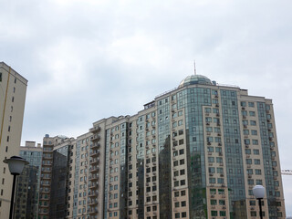 Fototapeta premium Sky above building crane at front of a multi-storey uilding under construction, new house for many families, babies and new life, building multi-storey building as symbol of hope to better life