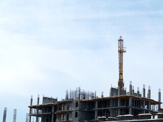 Sky above building crane at front of a multi-storey uilding under construction, new house for many families, babies and new life, building multi-storey building as symbol of hope to better life