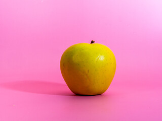 manzana verde sobre un fondo rosa
