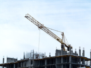 Sky above building crane at front of a multi-storey uilding under construction, new house for many families, babies and new life, building multi-storey building as symbol of hope to better life