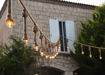 Decorative garden lighting design made with bulbs and thick rope