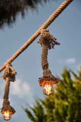 Decorative garden lighting design made with bulbs and thick rope