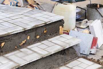 Laying paving slabs on the steps of the street staircase. Construction works