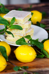 Sliced shortcake, many lemons and mint on wooden table