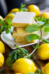 Sliced shortcake, many lemons and mint on wooden table