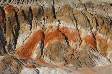 Mountain in a clay quarry. Close-up. A layer of red clay.