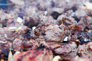 Grilled kebab cooking on metal skewer. Roasted meat cooked at barbecue. BBQ fresh beef meat chop slices. Traditional eastern dish, shish kebab. Grill on charcoal and flame, picnic, street food