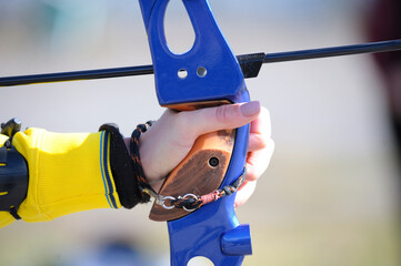 An archer hand pulling the string back of bow