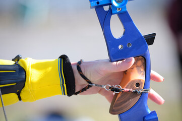 An archer hand pulling the string back of bow