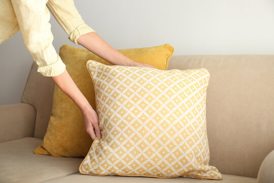 Woman Putting Pillow Onto Sofa, Closeup View. Interior Design