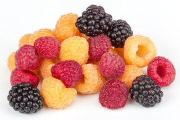 Lot of organic red and yellow raspberries and black blackberries on white background. Selective focus