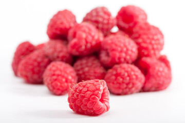 Lot of organic raspberries on white background. Selective focus