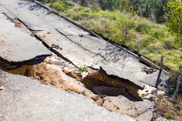 Broken road asphalt cracked and shifted by landslide after earthquake. Landslide caused by torrential rains of Hurricane CHRISTIE.