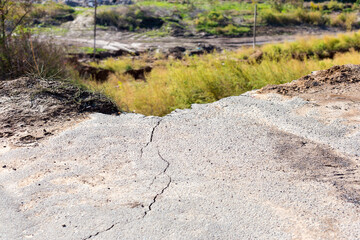 Broken road asphalt cracked and shifted by landslide after earthquake. Landslide caused by torrential rains of Hurricane CHRISTIE.