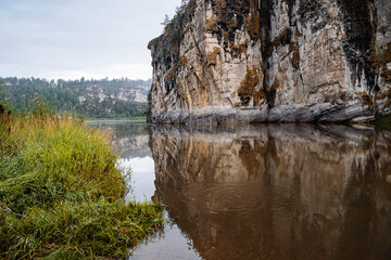 rock going into the river, stone cliff, morning on the river, fog, landscape in cloudy weather, Russia southern Urals Yuryuzan river, nature of Russia