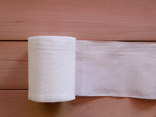Simple toilet paper on wood background.