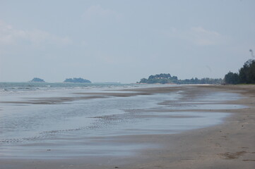 熱帯の誰もいない美しいビーチの波打ち際と向こうに見える島々