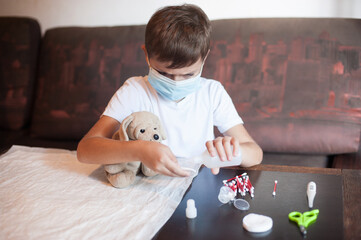 a boy of European appearance in a mask plays doctor . Game at home