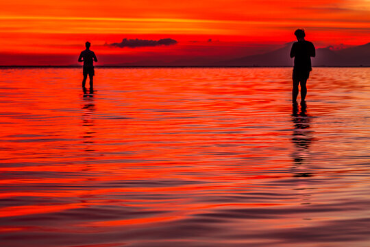 Two people silhouetted against the sunset