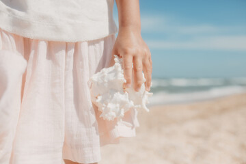 Curly young toddler girl with sea shell