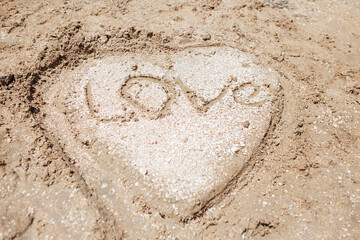 Heart from sand and small sea shells on the sea beach
