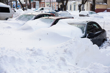 Odessa, Ukraine - January 01, 2015: Snow drifts in the city on a winter frosty day. Car blocked in the yard by snowdrifts after the heavy snow storm