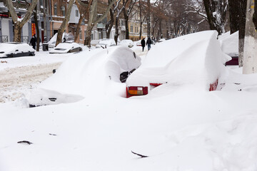 Odessa, Ukraine - January 01, 2015: Snow drifts in the city on a winter frosty day. Car blocked in the yard by snowdrifts after the heavy snow storm