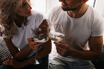 Couple clinking wineglasses. Indoor photo of man and woman drinking champagne.