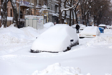 Odessa, Ukraine - January 01, 2015: Snow drifts in the city on a winter frosty day. Car blocked in the yard by snowdrifts after the heavy snow storm